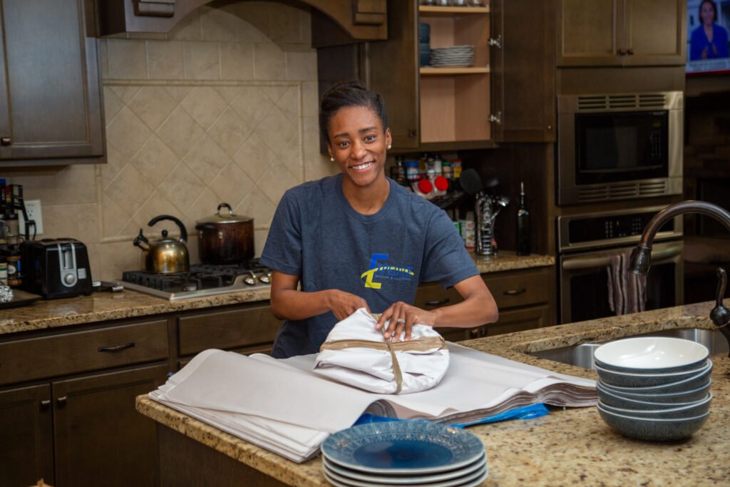 Expert packer, Sarai, packing up Fayetteville kitchen and wrapping up dinner plates.