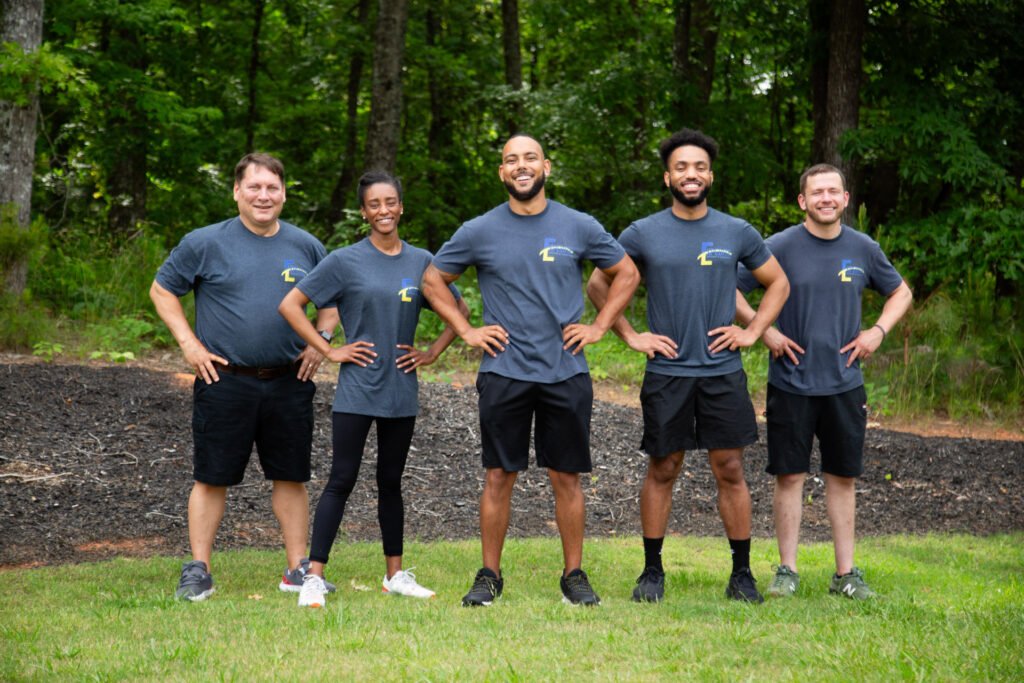 The expert movers at Expedite Moving lined up with hands on hips.